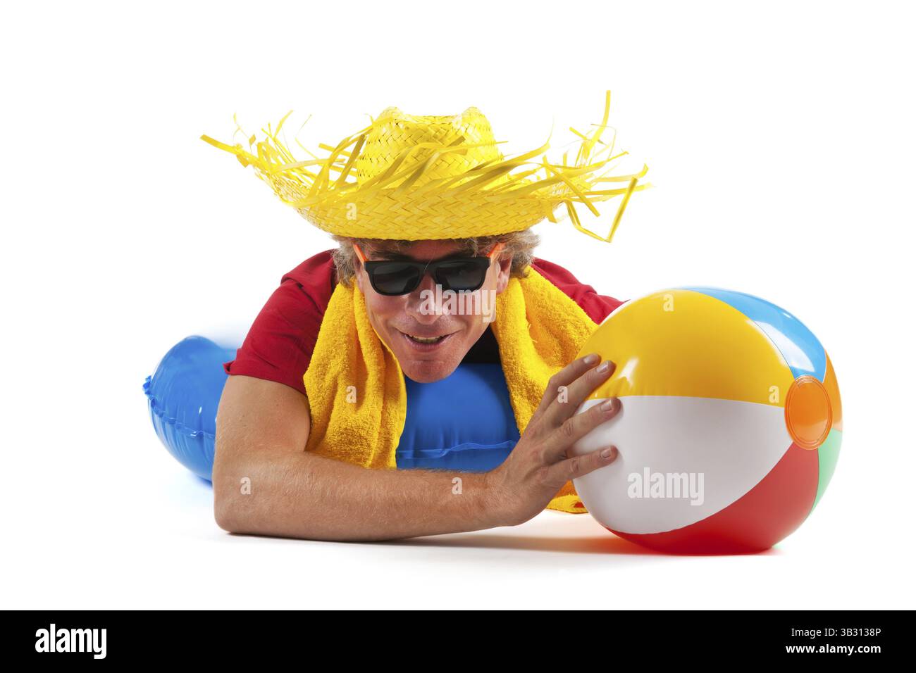 Uomo adulto si posa su un galleggiante con palla spiaggia Foto Stock