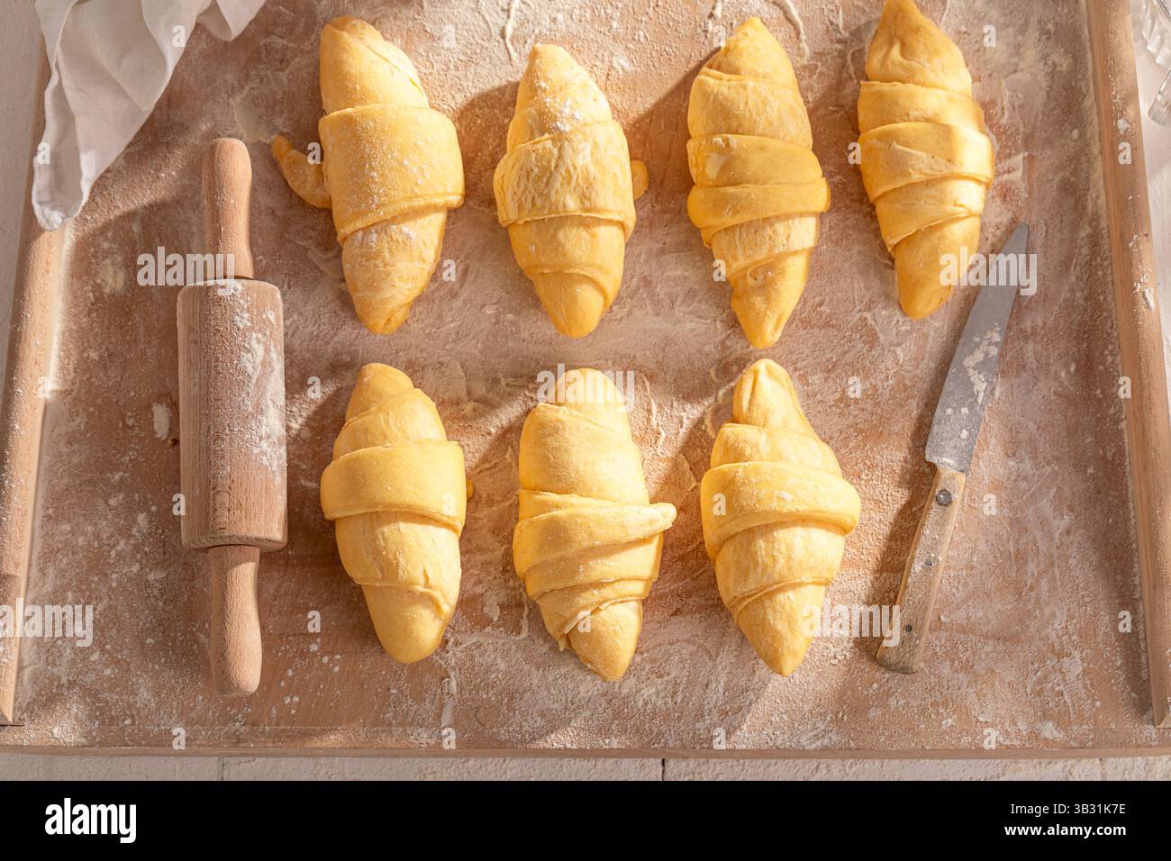 Tradizionale preparazione di croissant francesi per cuocere in casa. Preparare croissant a casa. Foto Stock