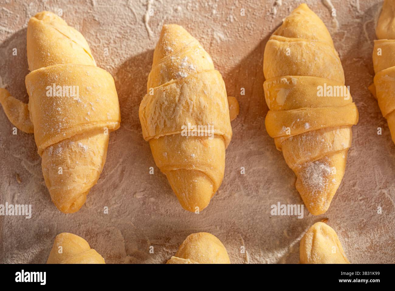 I tradizionali croissant francesi sono preparati su una tavola di pasticceria. Preparare croissant a casa. Foto Stock