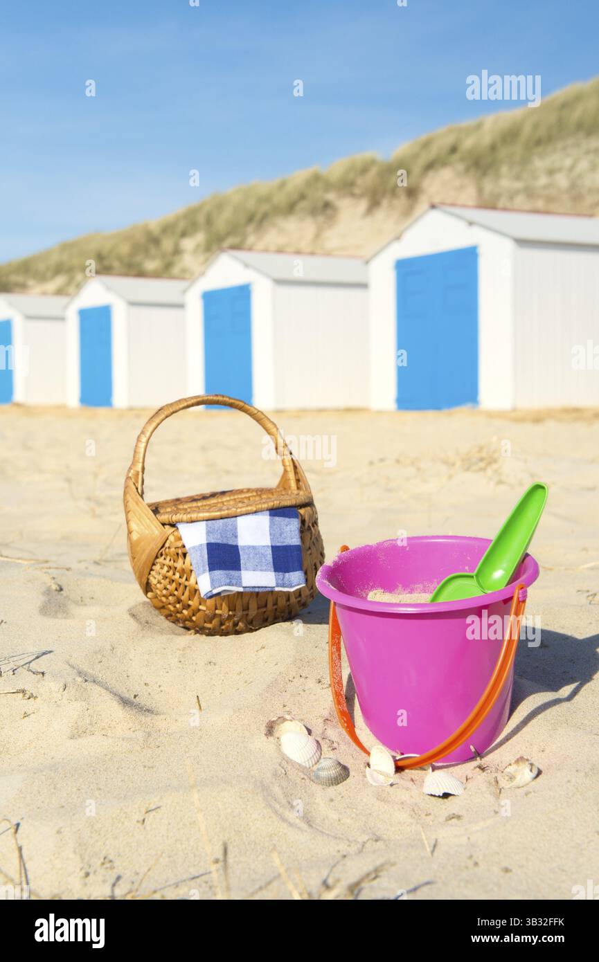 Riga blu e bianco cabine da spiaggia giocattoli e cesto per pic-nic Foto Stock