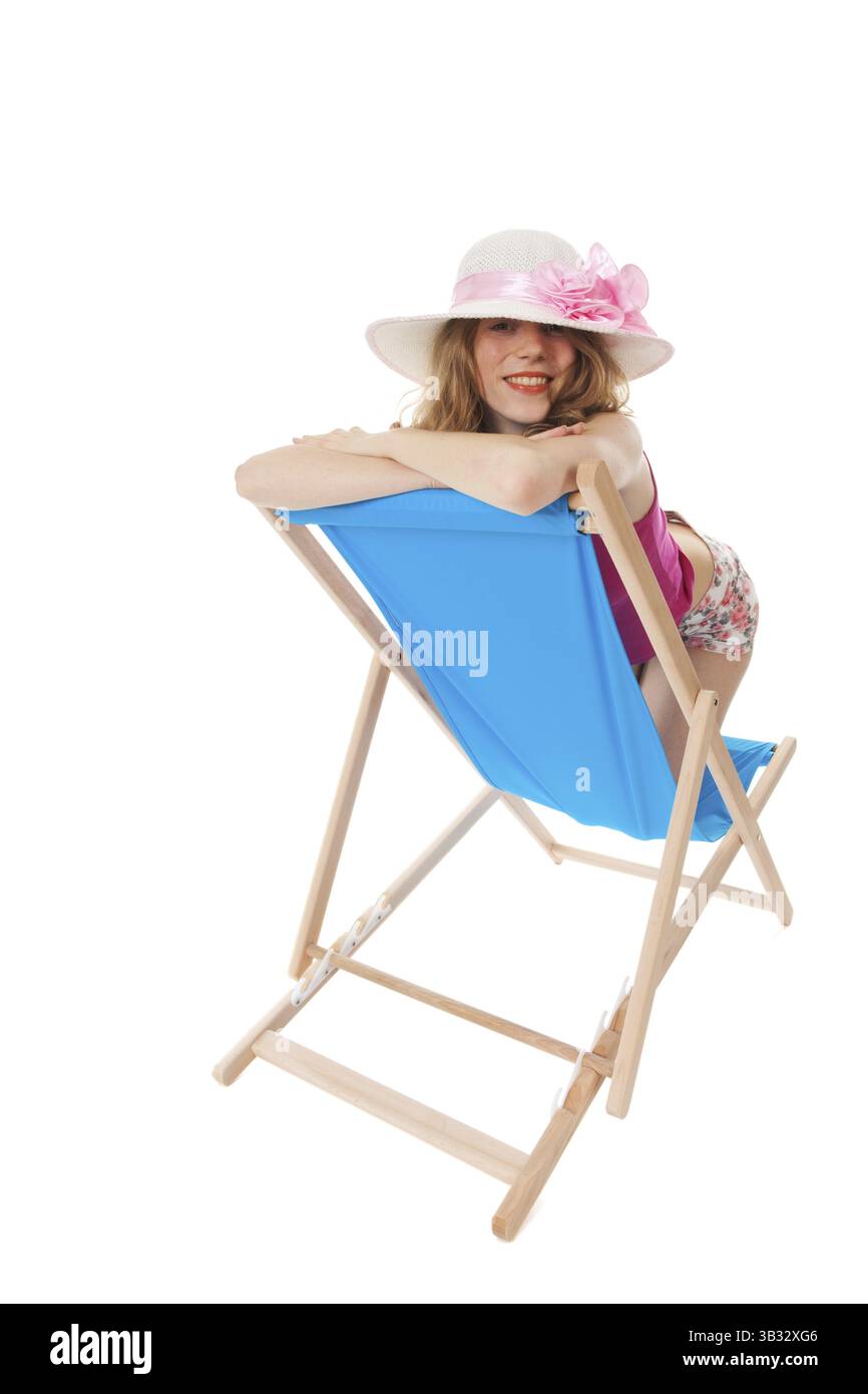 Giovane donna bionda sulla spiaggia blu sedia Foto Stock