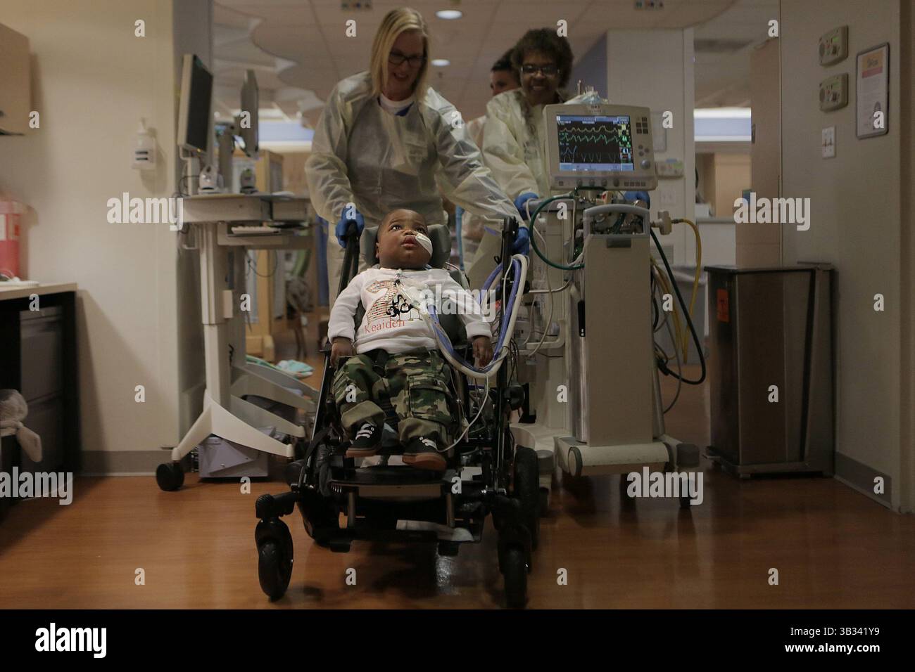 14 novembre 2015 - St. Louis, MO, Stati Uniti - KE'aiden Proctor e un team di operatori sanitari compiono con attenzione un breve viaggio lungo il corridoio dell'unità di terapia intensiva neonatale per la sua seconda festa di compleanno sabato 14 novembre 2015 all'ospedale pediatrico di St. Louis. E' solo una delle poche volte in cui KE'aiden e' uscito dalla sua stanza da quando si e' arrabbiato con i bambini È nato a 27 settimane, ha una malattia polmonare cronica e richiede cure 24 ore su 24 presso la NICU. (Immagine di credito: © Huy Mach/TNS via ZUMA Wire) Foto Stock