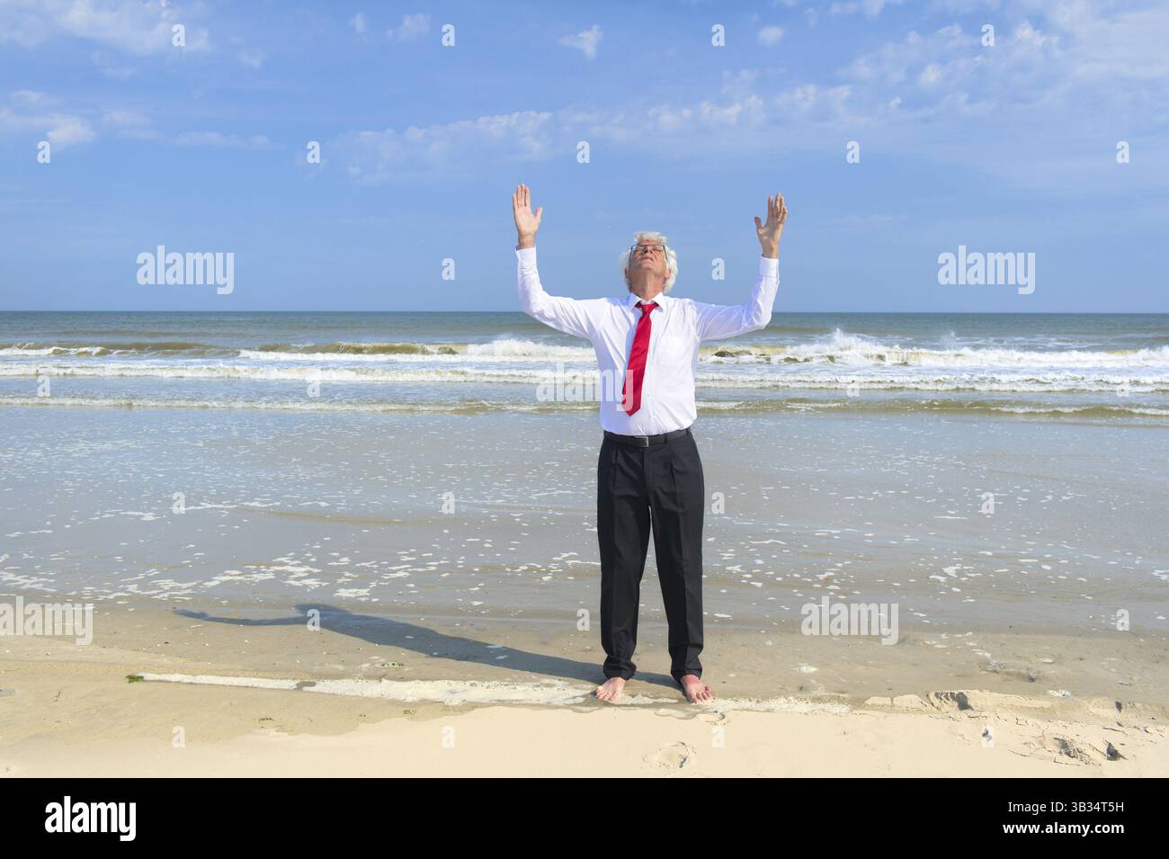 Uomo d'affari in formale tuta zen meditazione in spiaggia Foto Stock
