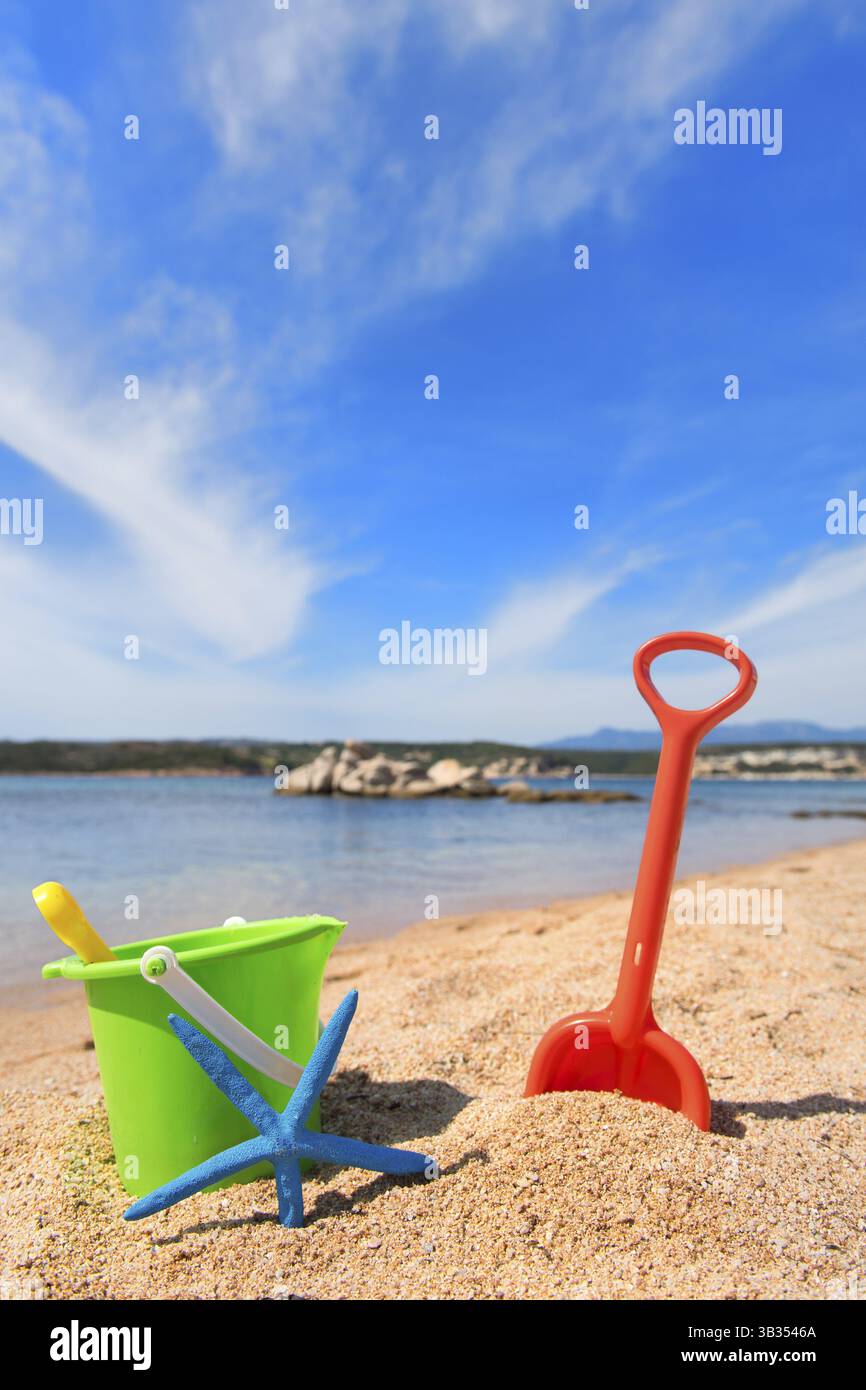 Spiaggia della Corsica con i giocattoli colorati e la stella di mare vicino all'acqua Foto Stock