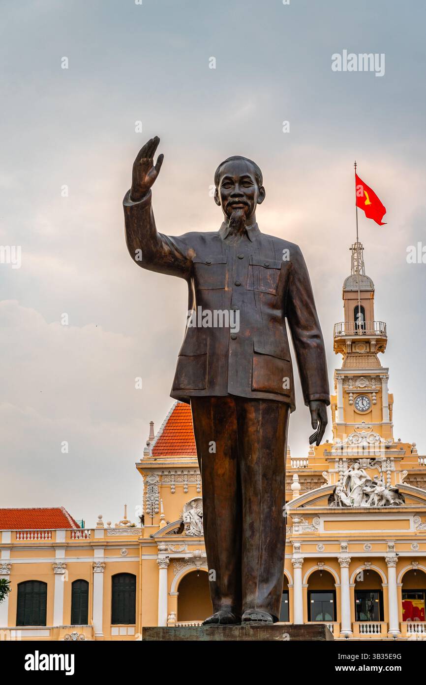 Ho chi Minh City (Saigon), Vietnam - 15 febbraio 2025: Statua di ho chi Minh sulla passeggiata di Nguyen Hue con l'edificio governativo UBND Thành. Foto Stock