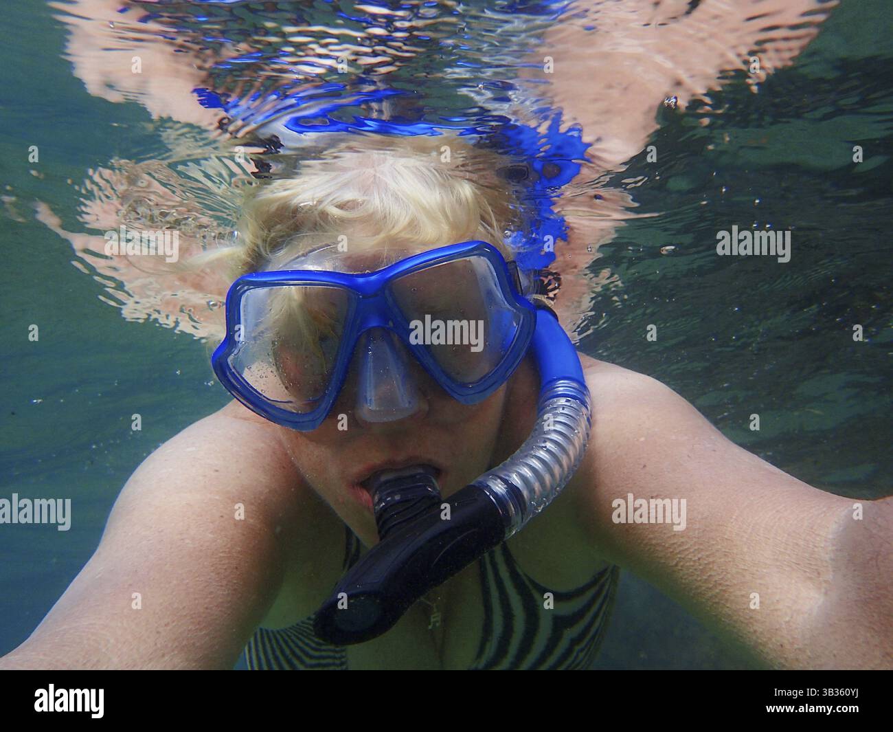 Donna anziana sott'acqua con maschera subacquea Foto Stock