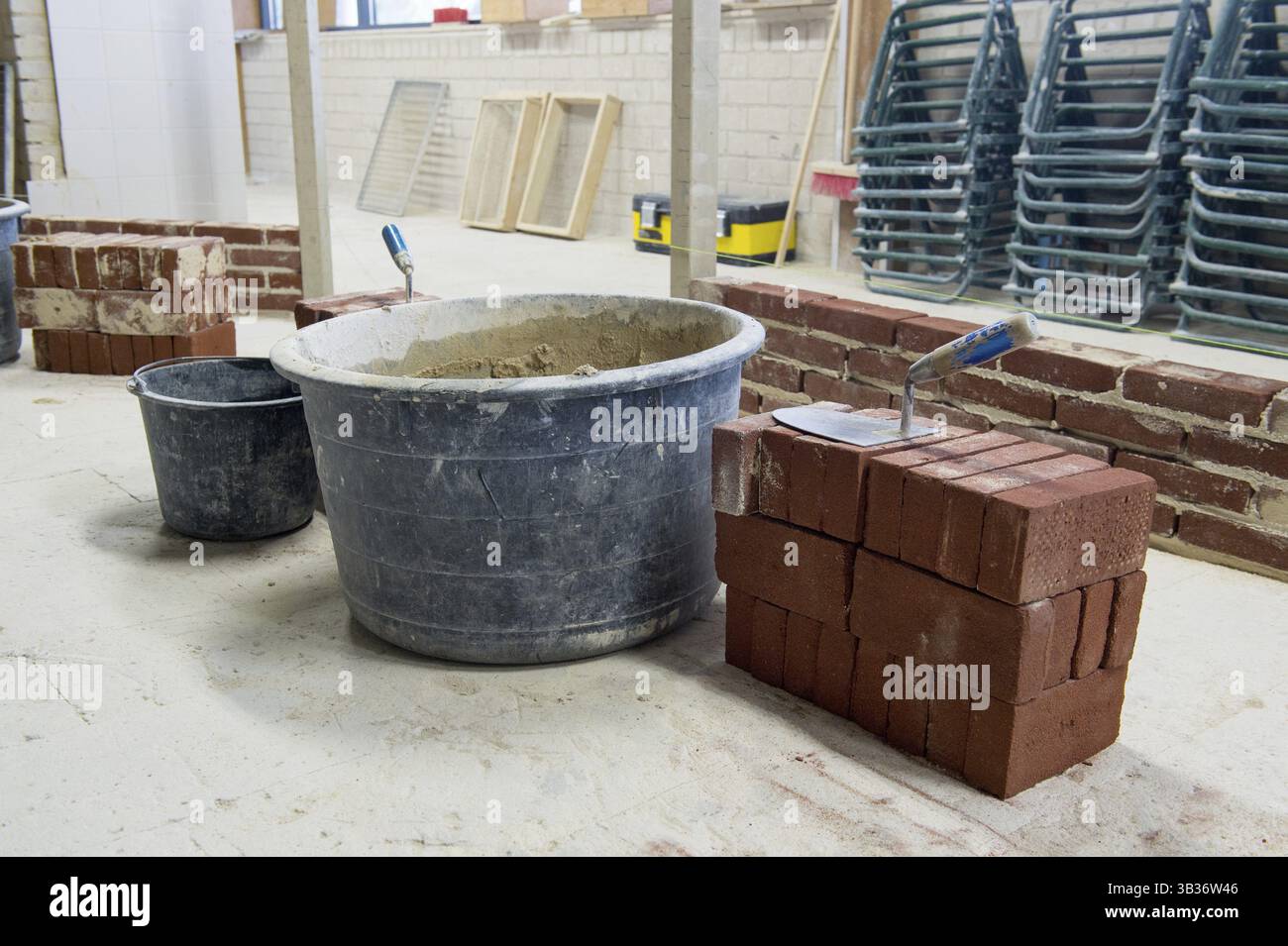 Cazzuola, mattoni e cemento per pareti da costruzione Foto Stock