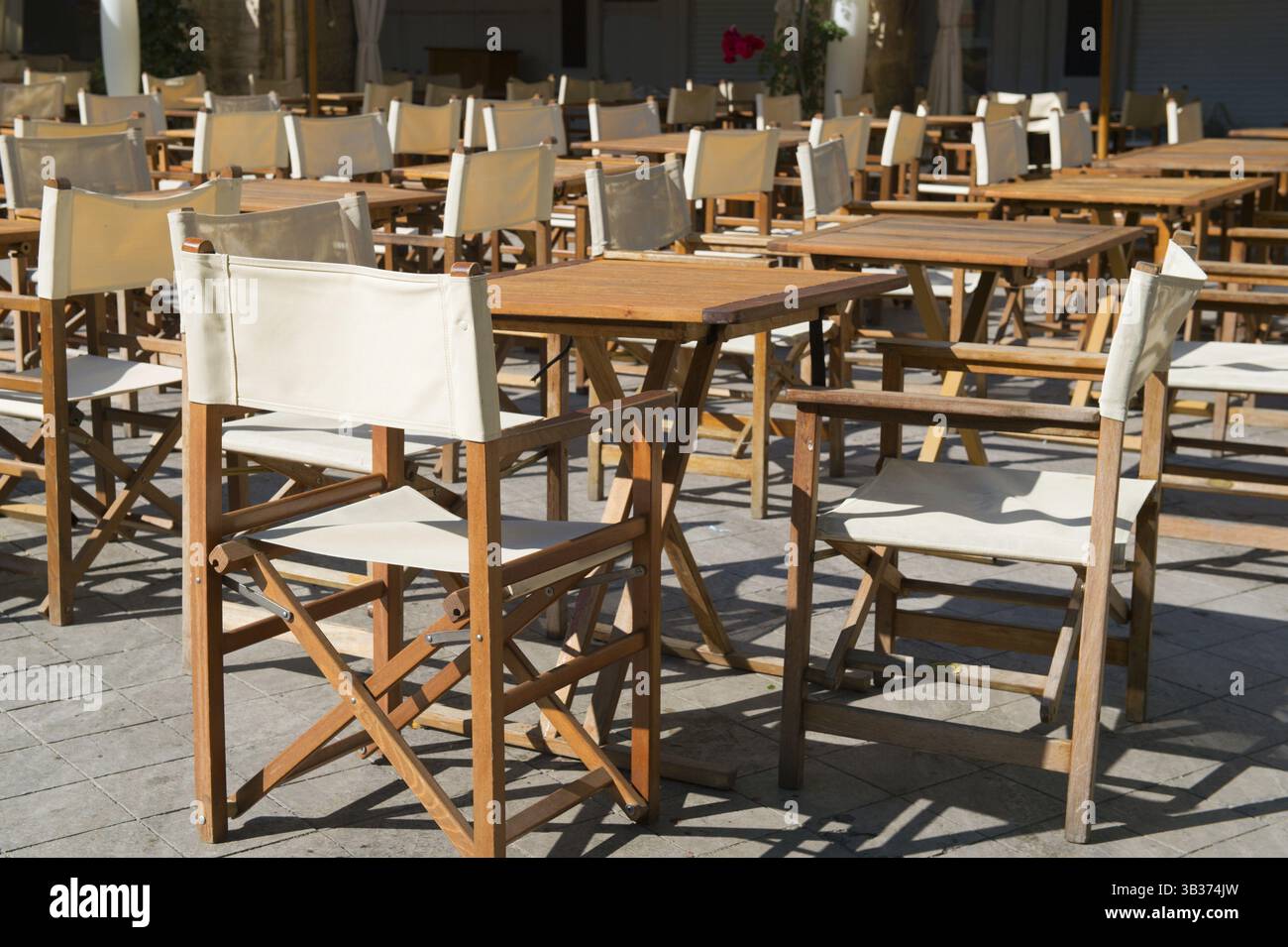Terrazza con sedie in tela e tavoli in legno Foto Stock