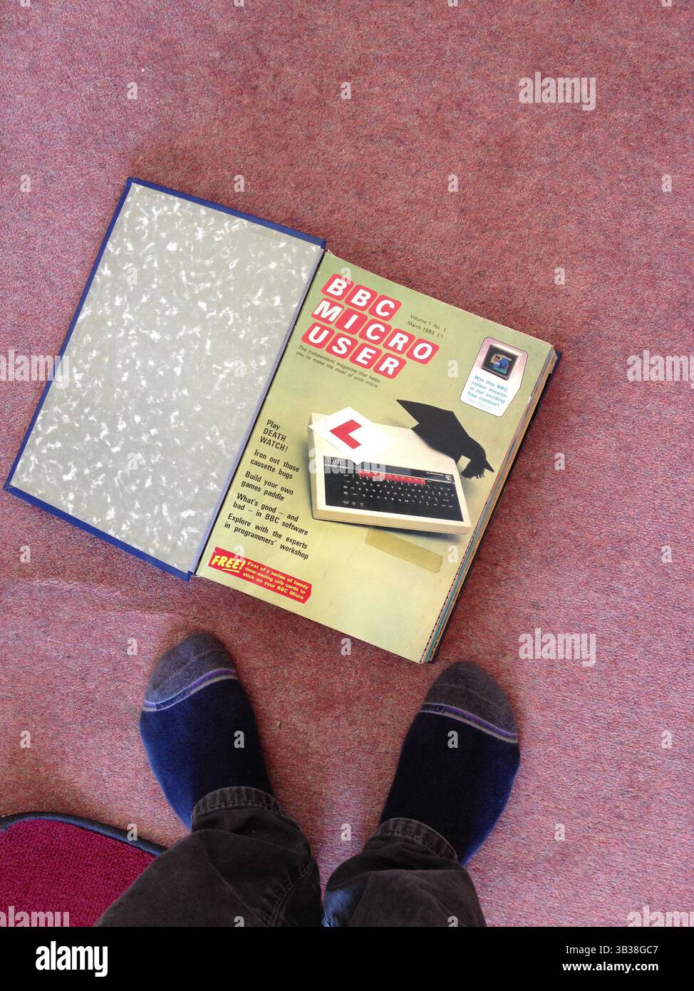 1983 01 marzo - Londra, Regno Unito - BBC Micro computer e una rivista per gli utenti raffigurata sul fusto con i piedi maschili Foto Stock