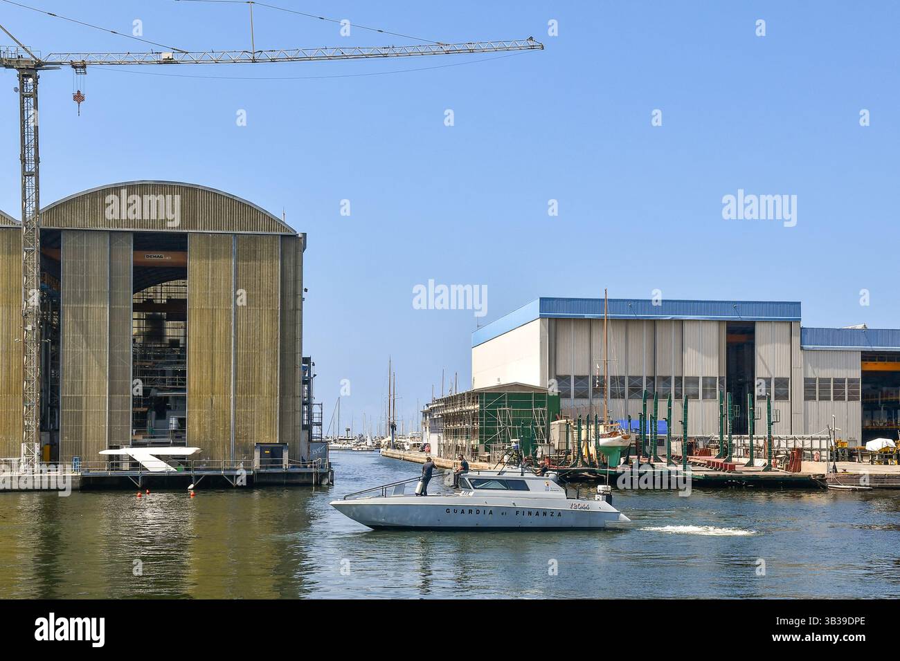 Motoscafo della polizia di Finanza di fronte ai cantieri navali Azimut Benetti (a sinistra) e Francesco del Carlo nella Darsena Italia, Viareggio Foto Stock