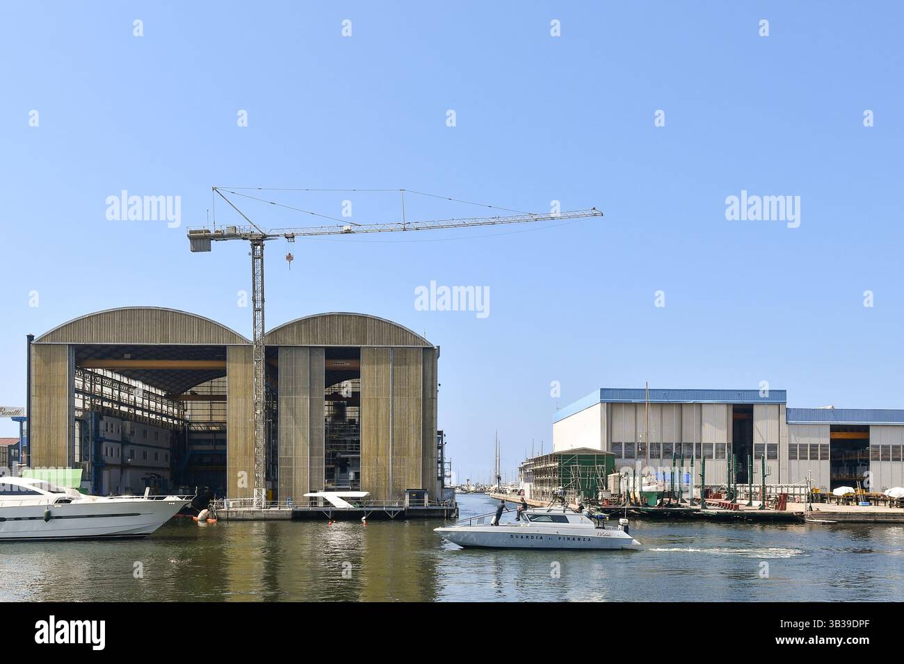 Motoscafo della polizia di Finanza di fronte ai cantieri navali Azimut Benetti (a sinistra) e Francesco del Carlo nella Darsena Italia, Viareggio Foto Stock