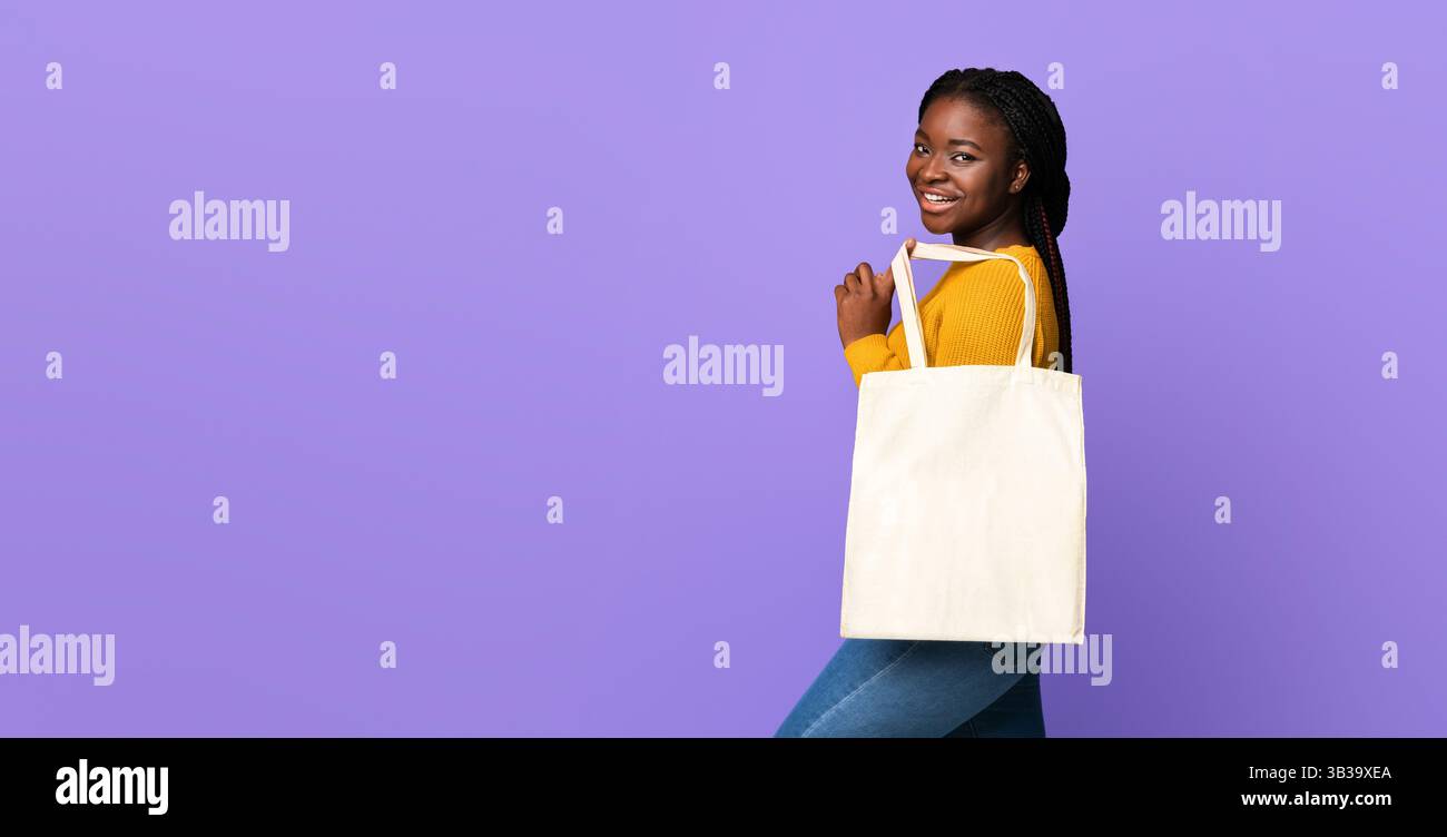 Gioiosa donna africana in posa con borsa tote vuota con Mockup Per progettazione Foto Stock