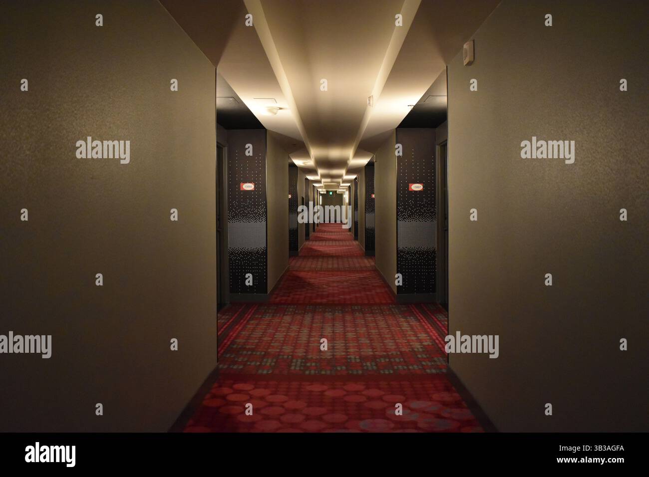 Corridoio di un hotel d'epoca con illuminazione soffusa e arredamento retrò, evocando fascino senza tempo e atmosfera nostalgica. Foto Stock