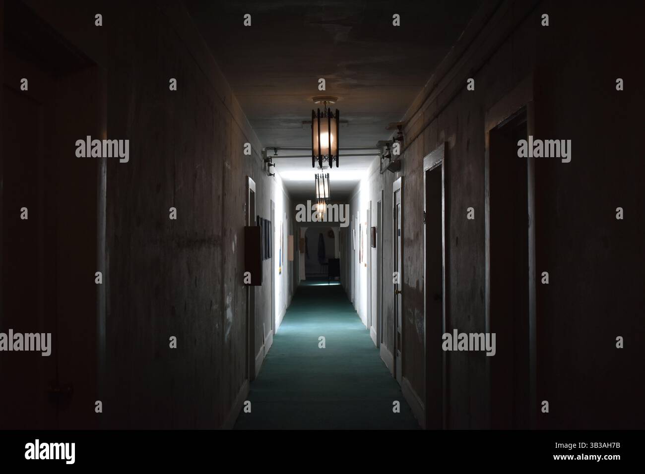 Corridoio di un hotel d'epoca con illuminazione soffusa e arredamento retrò, evocando fascino senza tempo e atmosfera nostalgica. Foto Stock