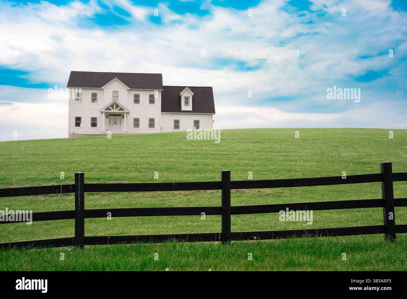 Casa bianca idilliaca con prato verde erboso e cielo blu Foto Stock