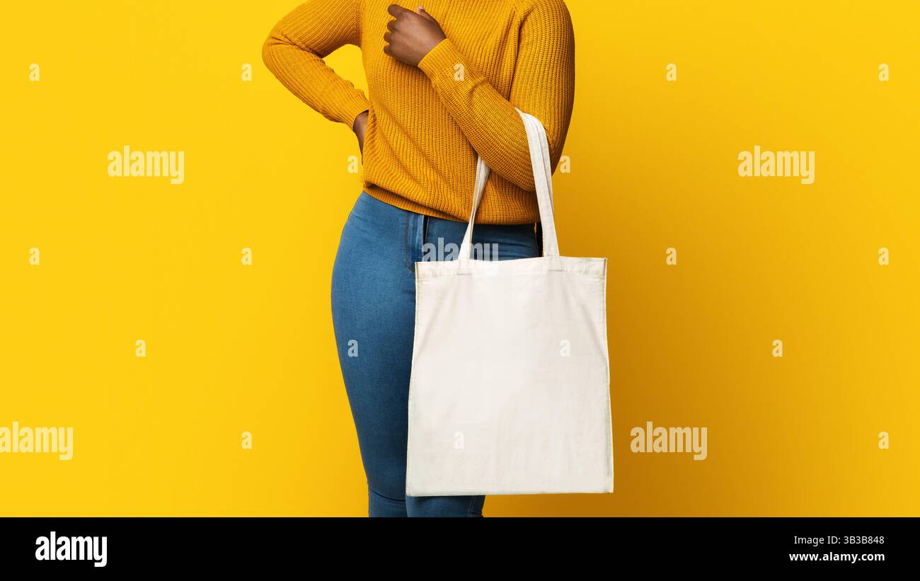 Mockup per il design. Allegro African American Lady Holding White Eco Tote Bag Foto Stock