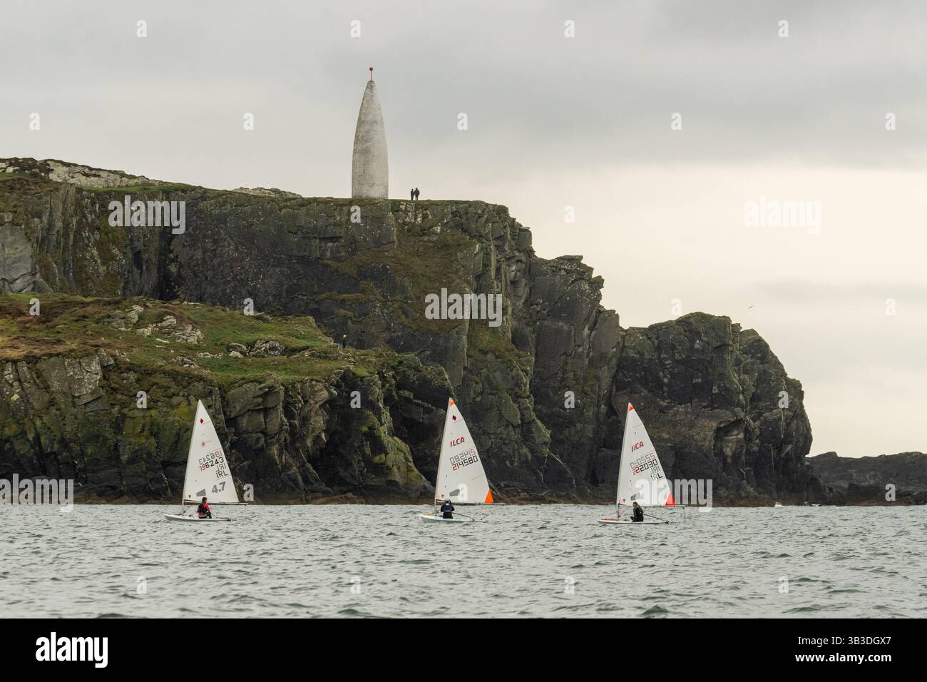 I concorrenti dell'ILCA Munster Championships laser boat navigano oltre il Baltimore Beacon nel porto di Baltimora, West Cork, Irlanda. Foto Stock