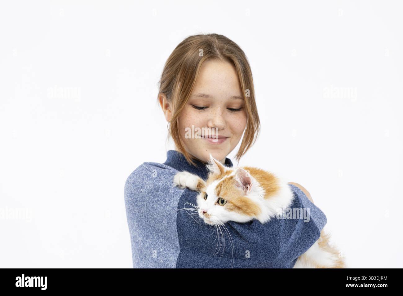 Una ragazza abbraccia il suo gatto soffice zenzero, mostrando splendidamente il loro legame amorevole in un'atmosfera accogliente e calda Foto Stock