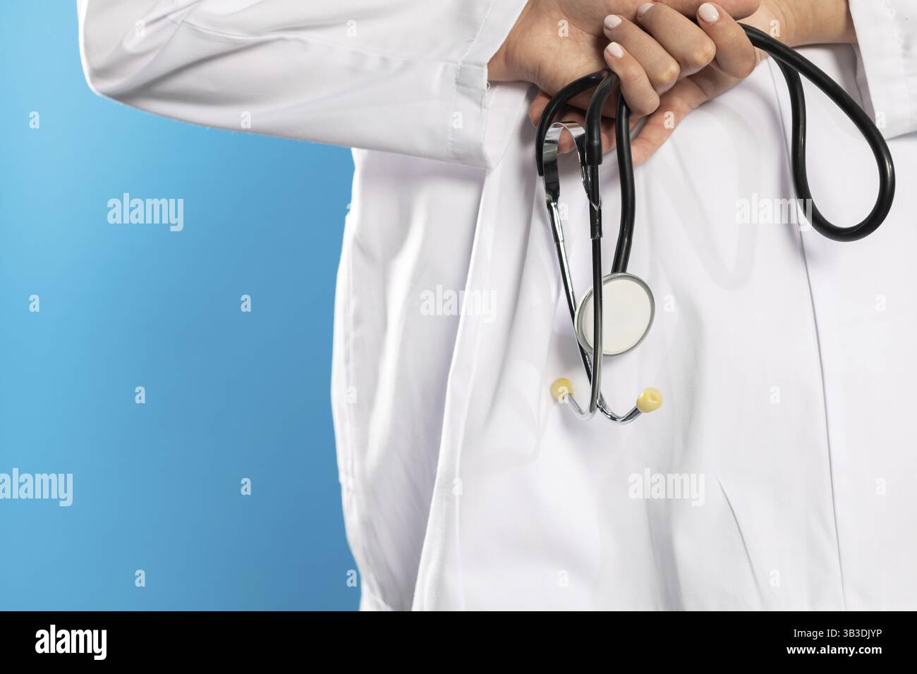 Vista posteriore con le mani di una giovane dottoressa che tiene in mano uno stetoscopio Foto Stock