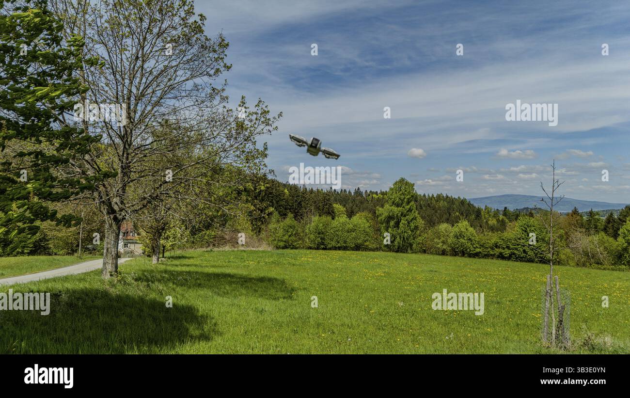 Un drone fotografico vola su un lussureggiante prato verde con alberi e un cielo blu sullo sfondo, Rossberg, Miltach, alto Palatinato Foto Stock Un drone fotografico vola su un lussureggiante prato verde con alberi e un cielo blu sullo sfondo, Rossberg, Miltach, alto Palatinato Foto Stock