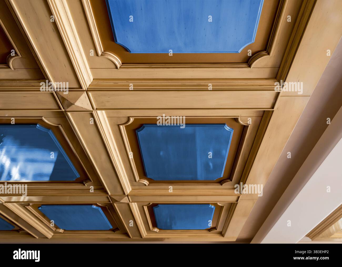 Pannelli in legno Сeiling con inserti blu. Vista prospettica di file di decorazioni in stile classico per soffitti in legno intagliato con macchina CNC. Foto Stock