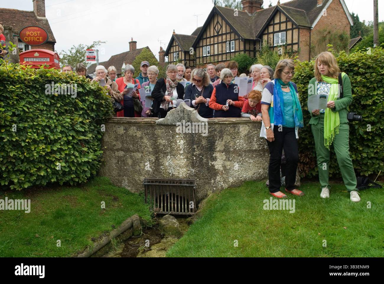 Pellegrini alla cerimonia annuale del Well Dressing di Kemsing, Kent. La chiesa di Santa Maria a Kemsing è stata il luogo di nascita nell'AD961 di Sant'Edith di Wilton, figlia illegittima del re sassone Edgar I. il pellegrinaggio al pozzo al centro del villaggio, che viene vestito ogni anno con un unico pozzo, viene svelata durante un breve servizio. Il pozzo è dedicato alla sua presenza sante; l'acqua del pozzo ha proprietà curative. Inghilterra 13 settembre 2014 Regno Unito 2010s HOMER SYKES Foto Stock