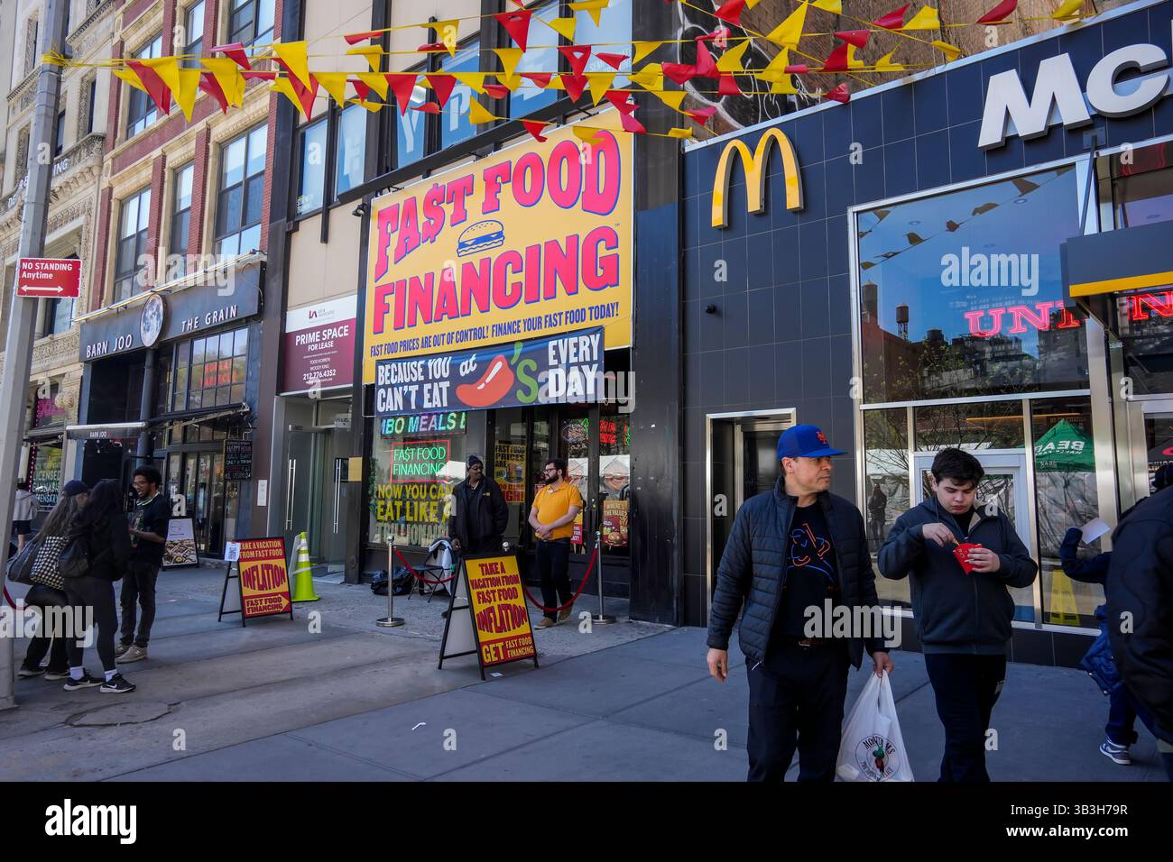 Gli amanti degli hamburger si esibiscono per ore fuori dal negozio ChiliÕs Grill & Bar ÒFast Food FinancingÓ a Union Square a New York giovedì 17 aprile 2025. L'attivazione del marchio è stata una promozione per il menu del ristorante chainÕs 3 for me, richiamando l'attenzione sul costo dei pasti di valore offerti in altre catene, tra cui il McDonaldÕs accanto. (© Richard B. Levine) Foto Stock