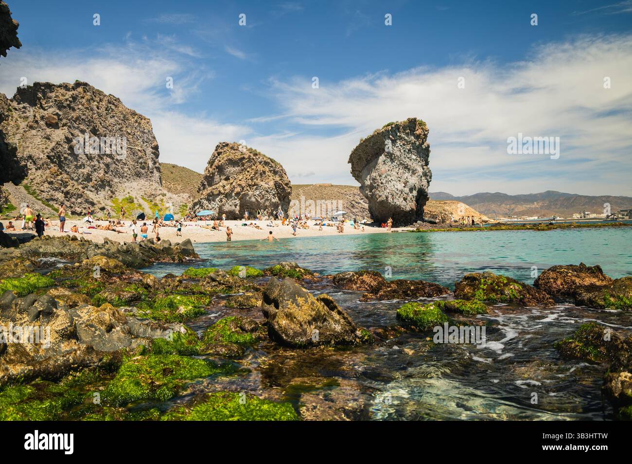 Questa foto panoramica orizzontale mostra le formazioni geologiche uniche e la vibrante atmosfera estiva di Playa de los Muertos a Murcia Foto Stock