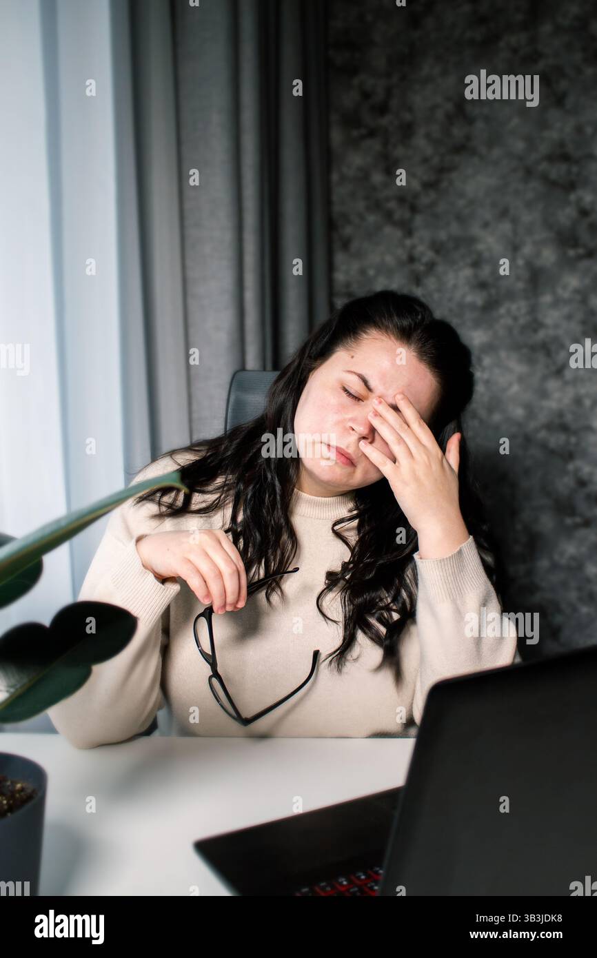 Donna caucasica stanca che si sente stressata da problemi di lavoro. Bruciatura da irritazione. Sfregamento degli occhi. Gestione delle scadenze di lavoro. Non dormi abbastanza. Foto Stock
