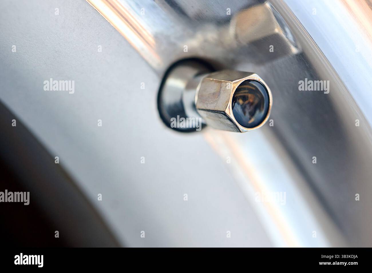 Dettaglio vettura immagine del dado del tappo esagonale del coperchio della valvola del nipplo pneumatico primo piano selettivo Foto Stock