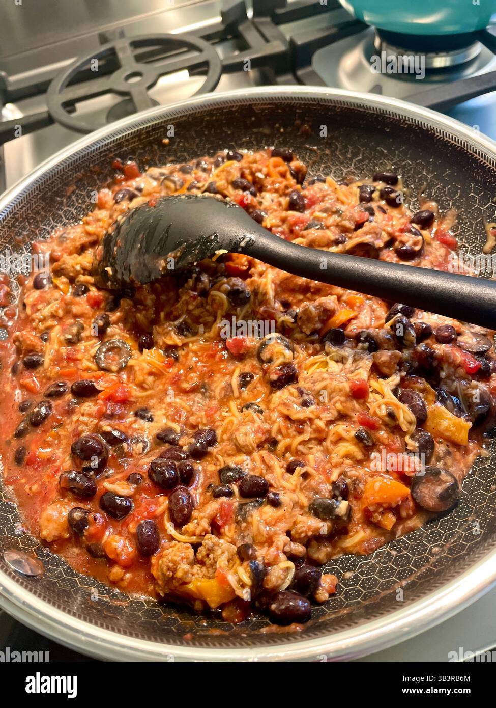 Fagioli neri e riso è un pasto tradizionale messicano, cucinato in una padella di cucina residenziale, 2025, Stati Uniti - Immagine stock catturata con smartphone
