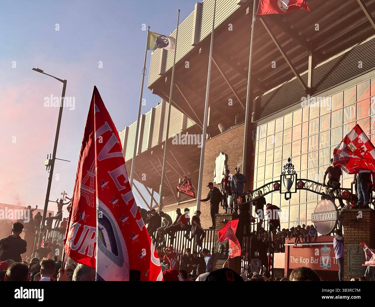 I tifosi festeggiano la vittoria della Premier League nelle strade fuori Anfield con bandiere e razzi rossi, 27 aprile 2025. - Immagine stock catturata con smartphone