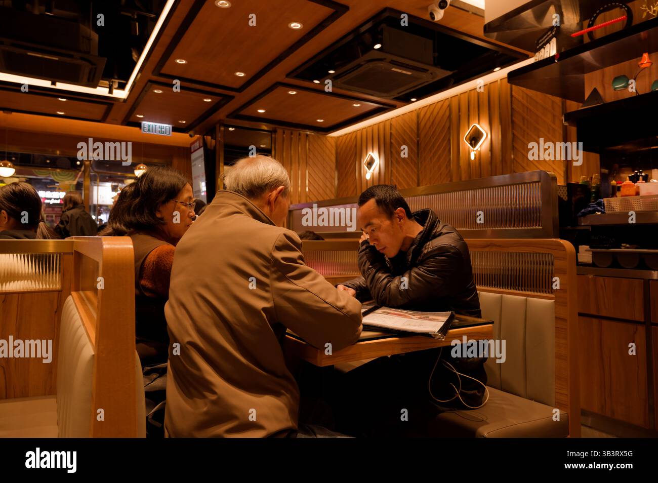 Un momento tranquillo in un caos di Hong Kong, dove i menu raddoppiano come pezzi di conversazione Foto Stock