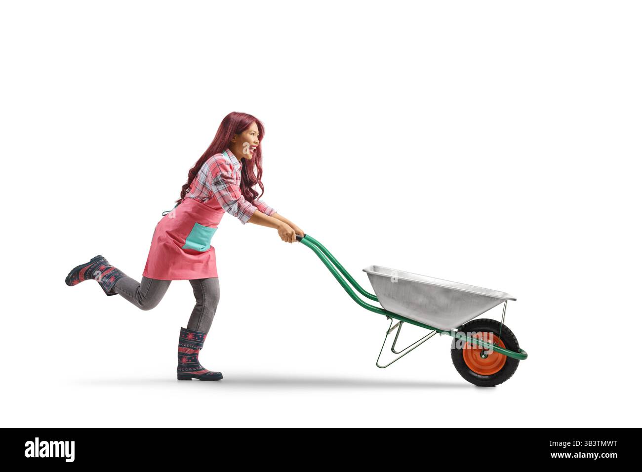 Eccitata giardiniera asiatica che spinge una carriola isolata su sfondo bianco Foto Stock