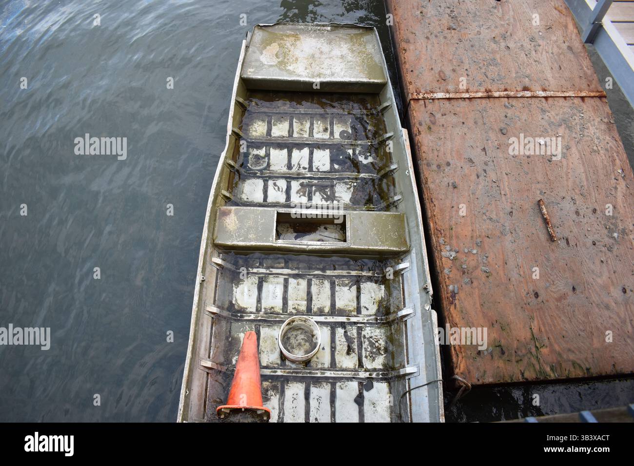 Vista aerea di una barca parzialmente sommersa in acqua, che mostra degrado, abbandono e suggestivi dintorni naturali. Foto Stock