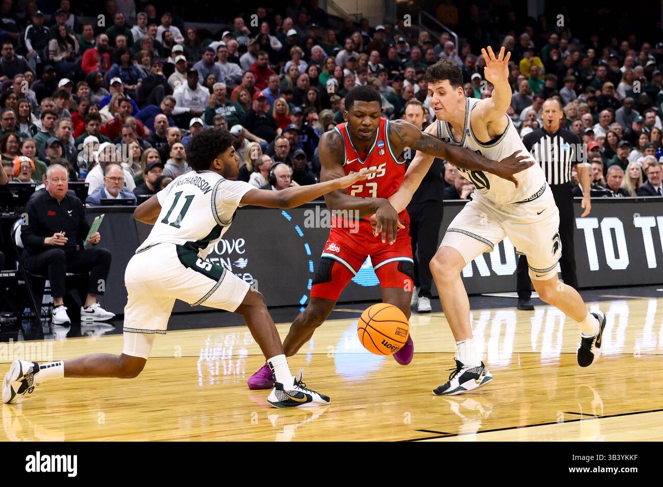 23 marzo 2025: Nelly Junior Joseph (23), centro di New Mexico Lobos, brilla la palla tra i difensori dei Michigan State Spartans durante la seconda metà del torneo di pallacanestro maschile New Mexico vs Michigan State NCAA - South Region - 2° round alla Rocket Arena di Cleveland, Ohio. Brian Fisher/CSM Foto Stock