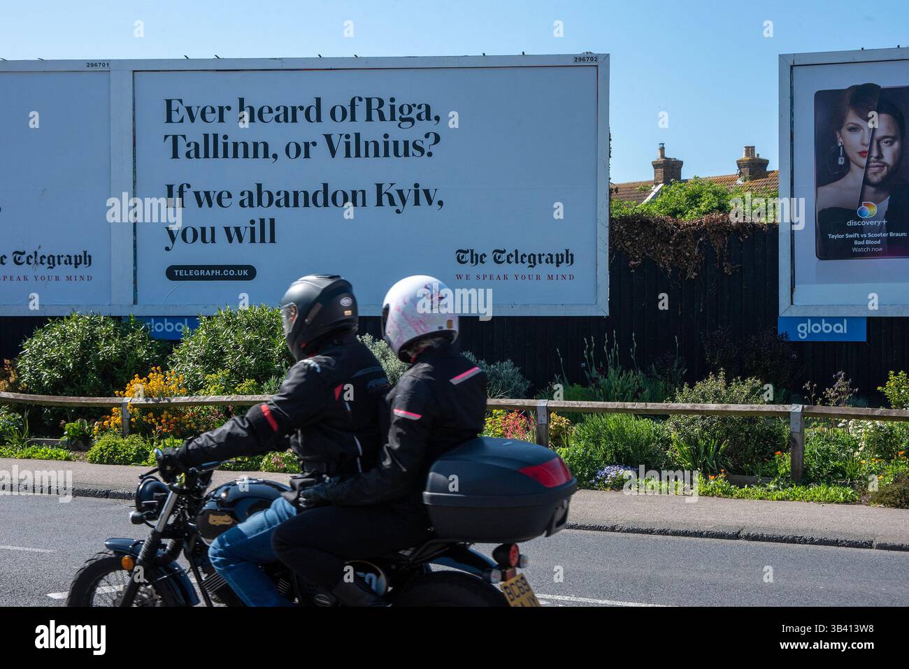 Birchington, Regno Unito. 29 aprile 2025. Un motociclista e un passeggero sul cartellone della campagna Telegraph a Birchington. La nuova campagna pubblicitaria del Telegraph mette in evidenza le prelibatezze russe sui paesi baltici (Lettonia, Estonia e Lituania), se l'Ucraina verrà abbandonata dal Regno Unito e dagli altri paesi occidentali. (Immagine di credito: © Krisztian Elek/SOPA Images via ZUMA Press Wire) SOLO PER USO EDITORIALE! Non per USO commerciale! Foto Stock