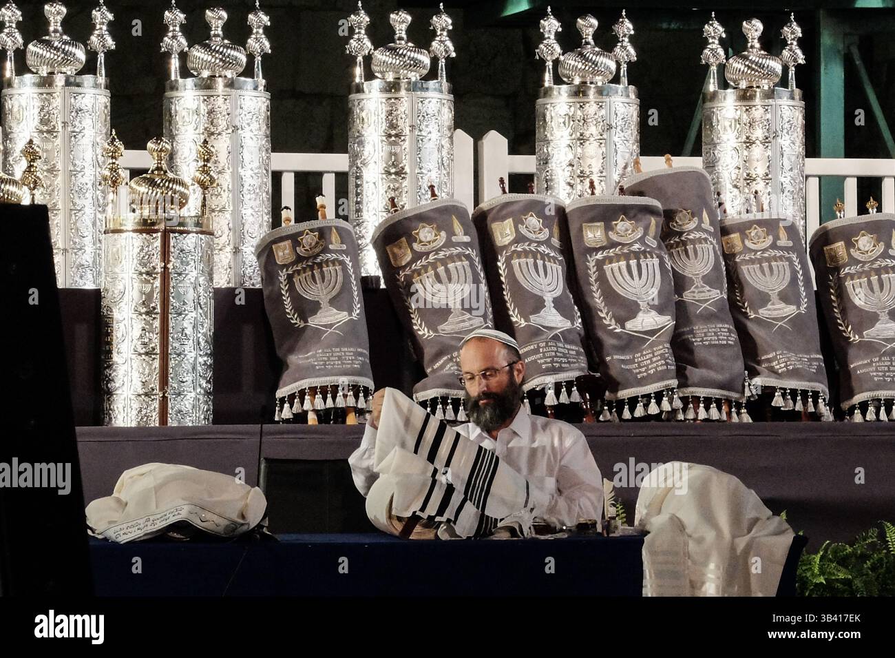12 agosto 2015 - Gerusalemme, Israele - Uno scriba ebreo si prepara a scrivere le ultime lettere in un nuovo rotolo della Torah. Settantacinque rotoli della Torah, una donazione di comunità ebraiche in tutto il mondo, sono stati cerimonialmente accolti presso il muro Occidentale in commemorazione dei caduti militari dell'IDF e dei civili israeliani uccisi durante il conflitto israelo-Gaza del 2014, nota anche come operazione bordo protettivo. (Immagine di credito: © Nir Alon via ZUMA Wire) Foto Stock