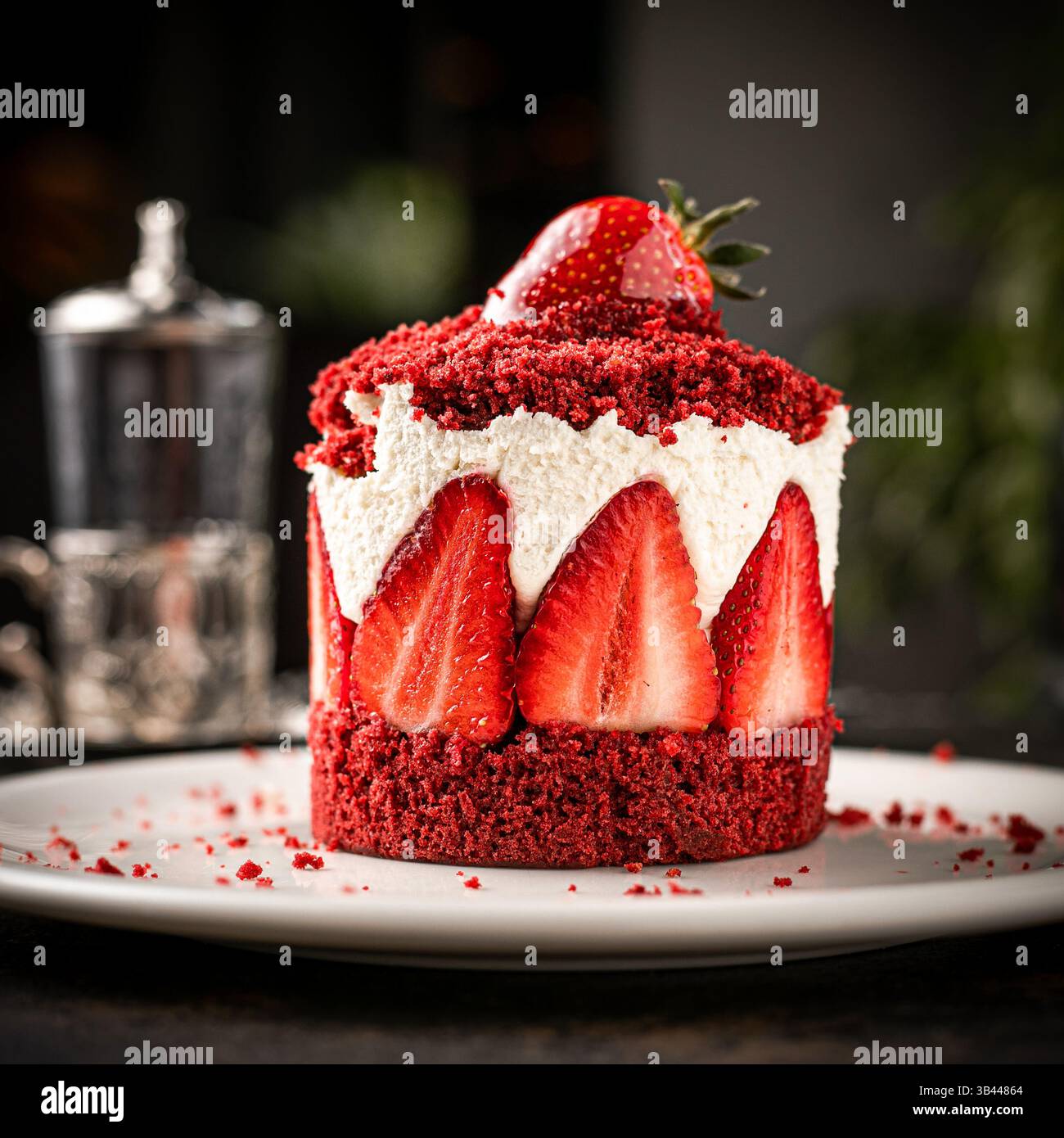 Ingrandire la vista della piccola torta rotonda decorata con fragole su piatto bianco Foto Stock