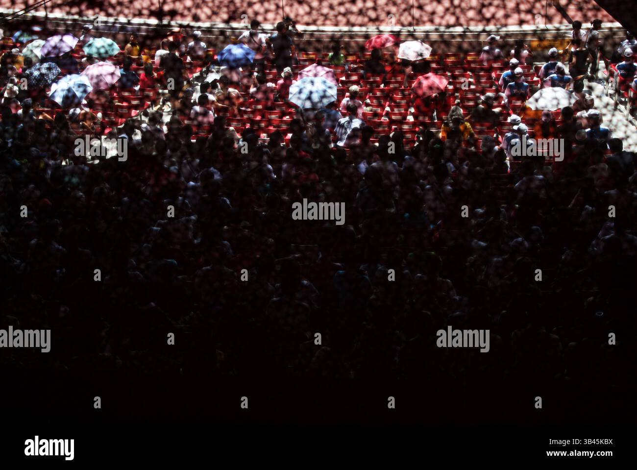 Folla di spettatori con ombrelloni all'interno dello Stadio Nazionale di Pechino durante le Olimpiadi del 2008 Foto Stock