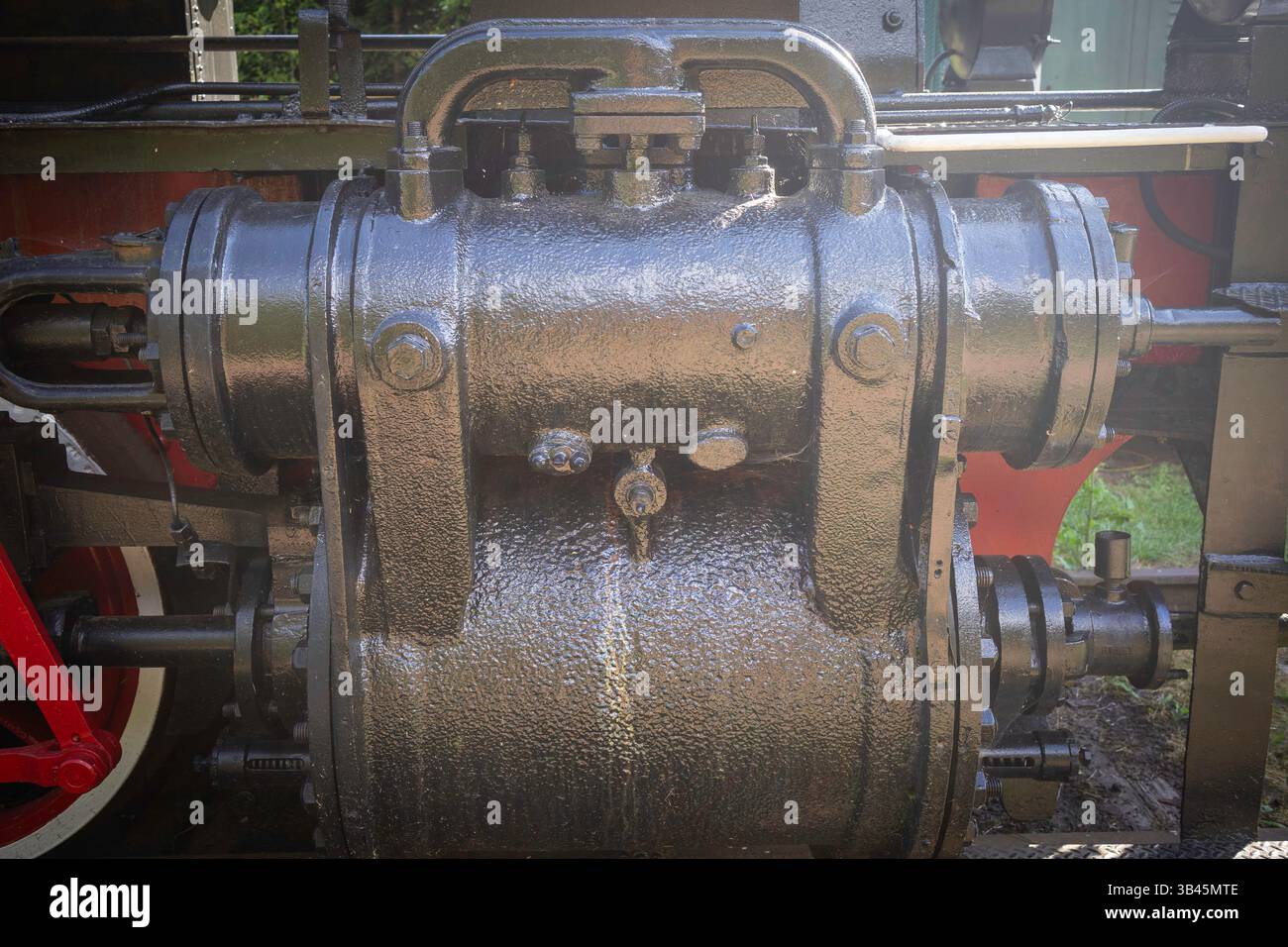 Un motore nero con una maniglia nera e rossa. L'impugnatura è rivestita di vernice nera. Il motore è vecchio e arrugginito Foto Stock