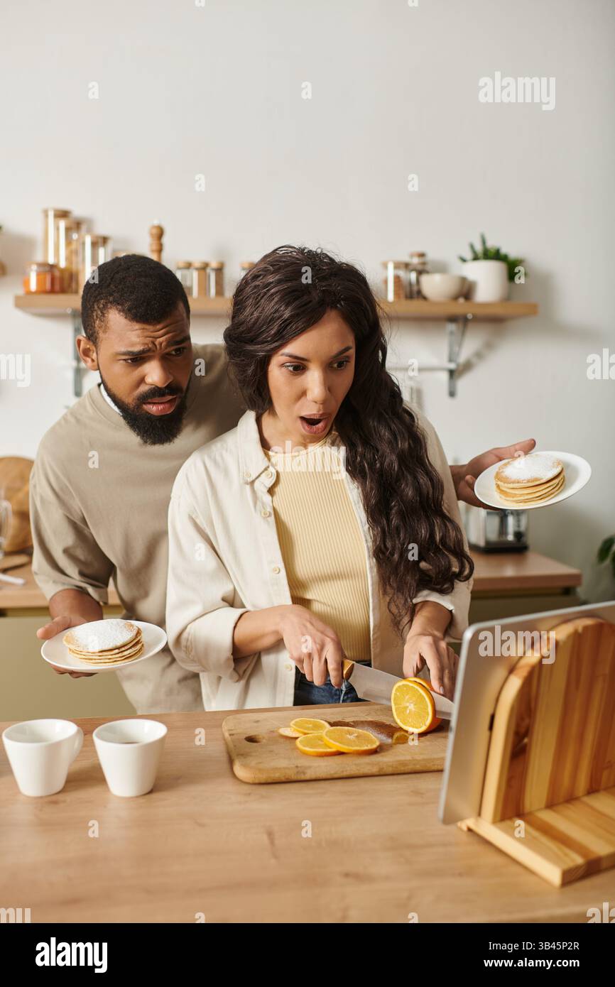 Le coppie condividono un momento di grande emozione nella loro cucina mentre preparano un pasto insieme con gioia. Foto Stock