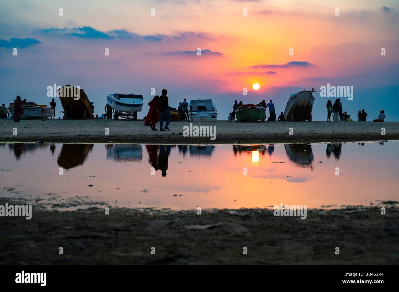 Tramonto sulla spiaggia di Colva Goa nell'India meridionale, silhouette di barche e persone, costa occidentale tropicale, Mar Arabico in Asia, destinazione turistica Foto Stock
