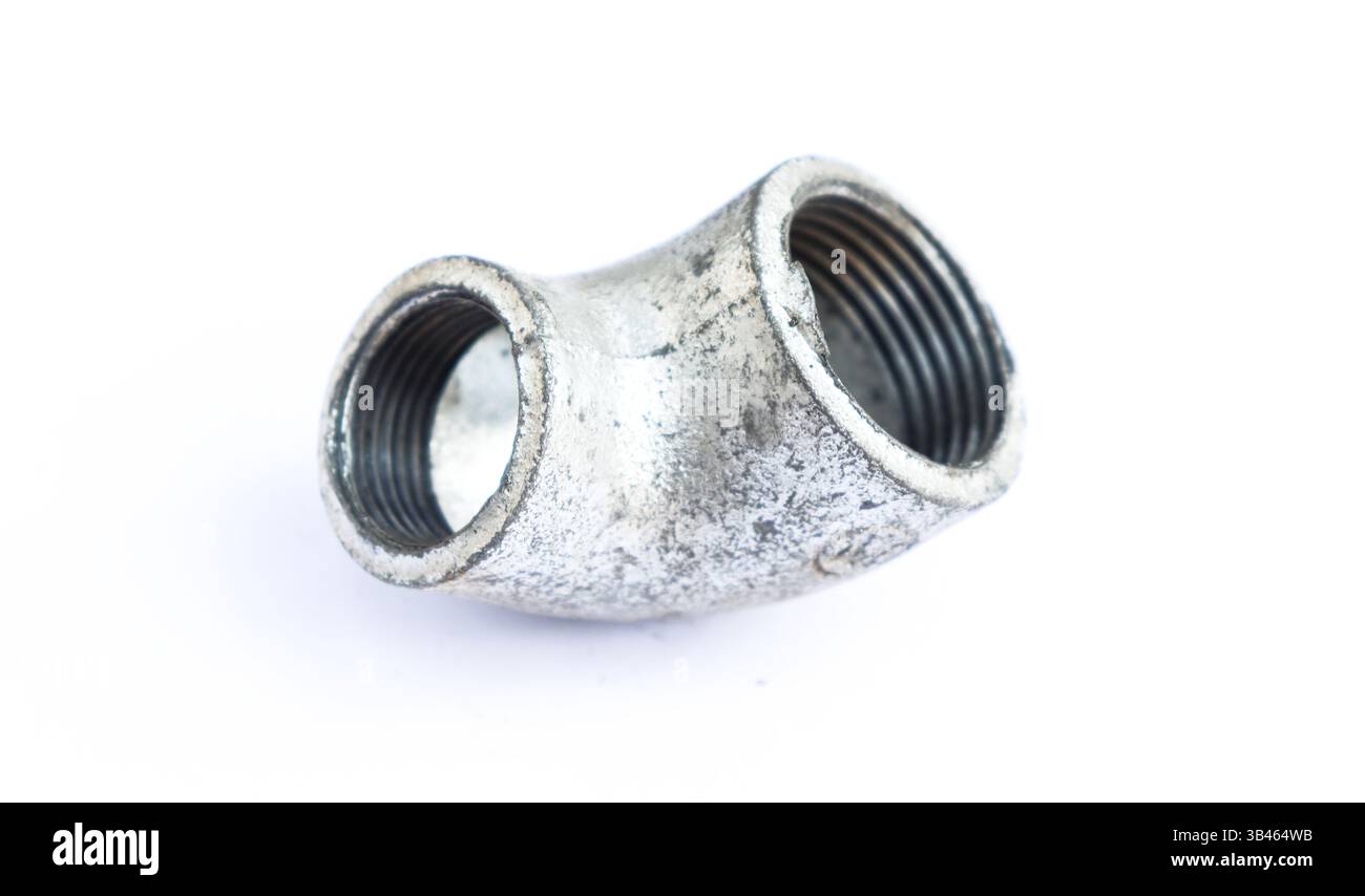 Primo piano di un robusto raccordo a T in metallo galvanizzato. Componente per tubazioni industriali dotato di un collegamento filettato su uno sfondo bianco pulito. Foto Stock