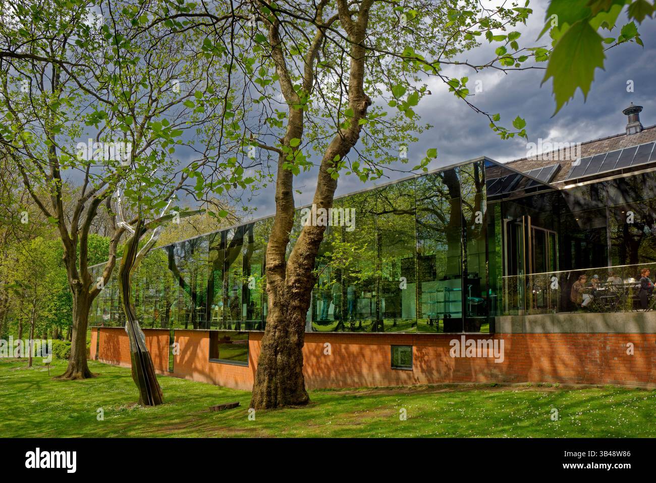 Facciata laterale dell'estensione della Whitworth Art Gallery a Manchester, Inghilterra. Questa vista include le opere d'arte simili ad alberi in acciaio inossidabile di Anya Gallaccio. Foto Stock