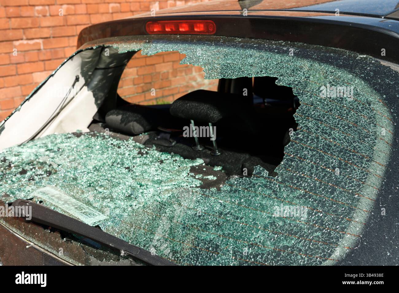 Un'auto berlina con un finestrino posteriore rotto Foto Stock
