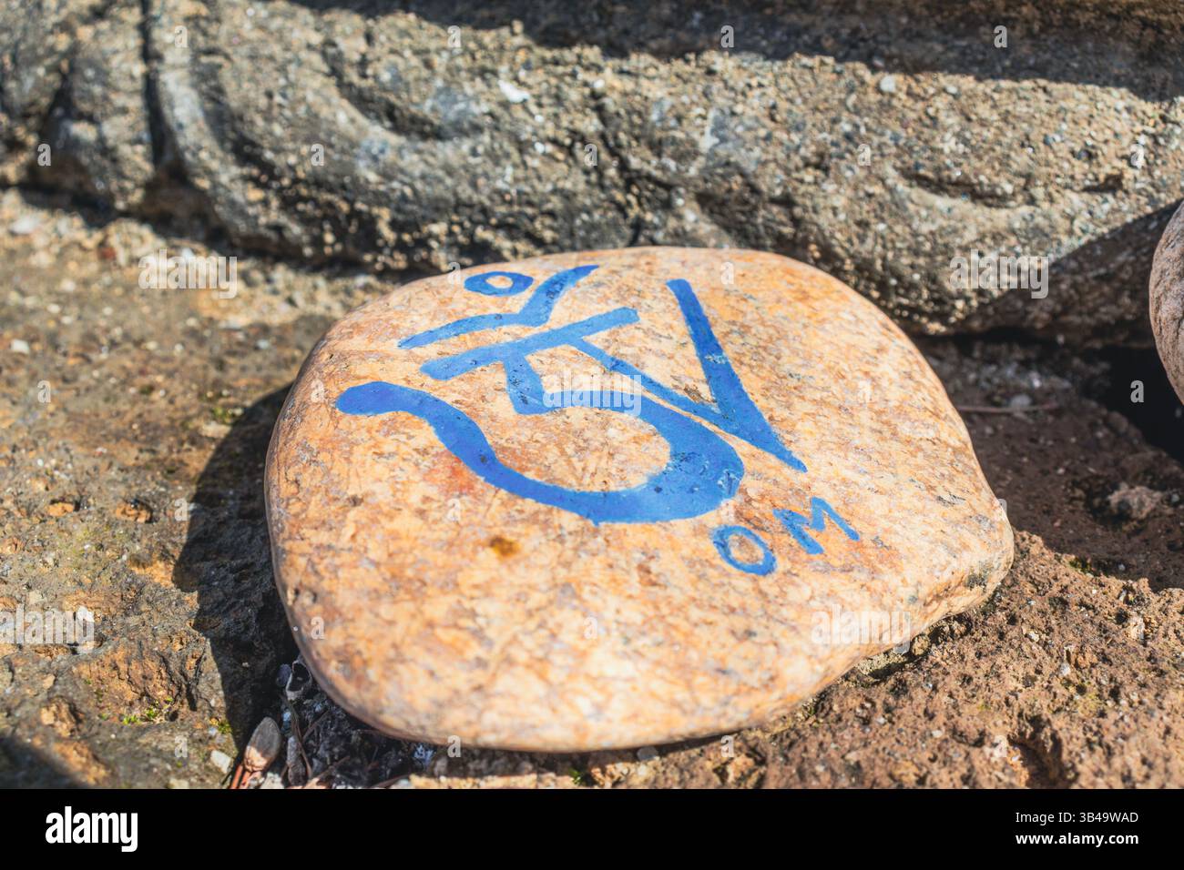 Simbolo OM inciso su una pietra. Primo piano, copia spazio. Foto Stock