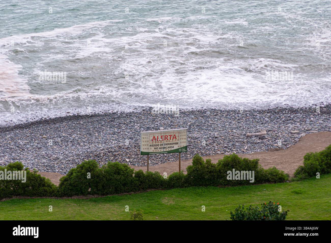 Cartello di attenzione con la scritta "avviso, rischio di frana, non avvicinarsi" su una spiaggia della Costa Verde nel quartiere San Isidro di Lima, Perù Foto Stock