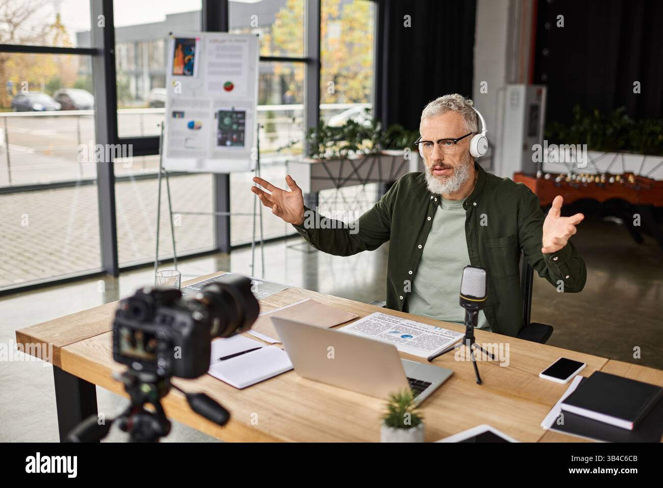 Un uomo professionista si impegna attivamente in una discussione virtuale, utilizzando un notebook durante i gesti. Foto Stock