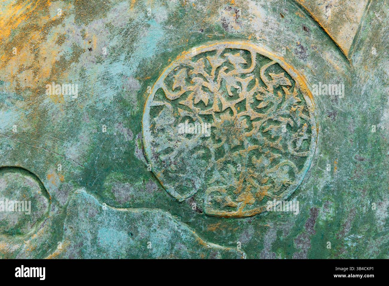 Superficie ruvida e resistente agli agenti atmosferici caratterizzata da un'intricata decorazione floreale circolare impressa all'interno, che evoca un senso di storia, arte e invecchiamento Foto Stock